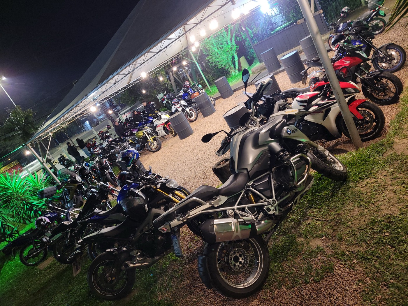 Motos do grupo estacionadas à noite em frente a um restaurante iluminado